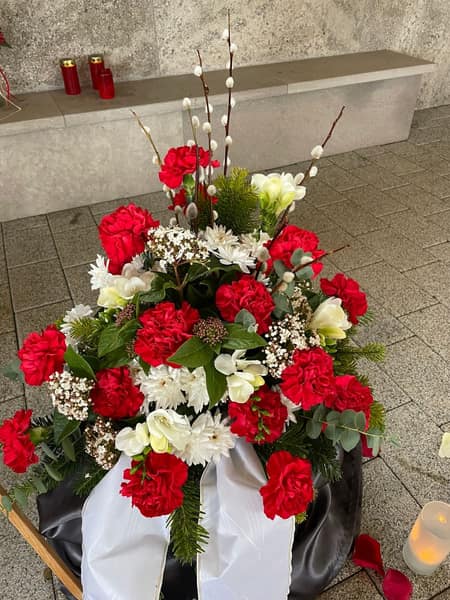 Gesteck aus roten Nelken und weißen Blüten