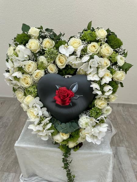 Herz aus weißen Rosen mit dunkler Urne