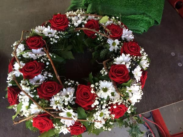 Trauerkranz aus roten Rosen und weißen Margeriten