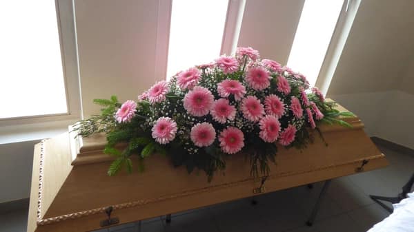 Sargbukett mit rosafarbenen Gerbera und Rosen