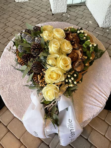 Winterlicher Strauß aus weißen Rosen mit Zapfen